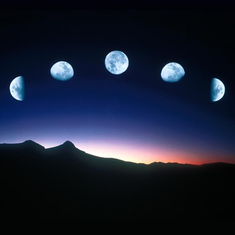 Phases of the moon over a mountain silhouette at dusk